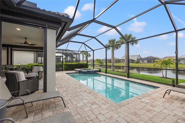 view of pool featuring a patio, a water view, glass enclosure, and an in ground hot tub