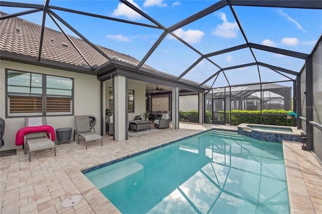 view of swimming pool featuring glass enclosure, an in ground hot tub, outdoor lounge area, ceiling fan, and a patio area