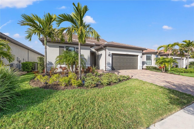 mediterranean / spanish house with a garage and a front lawn