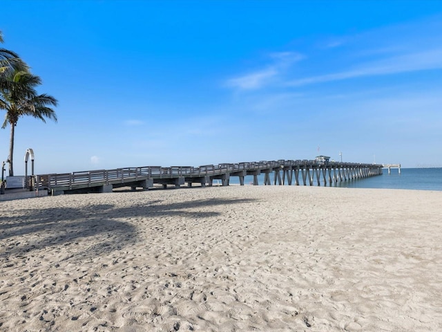 dock area with a beach view and a water view