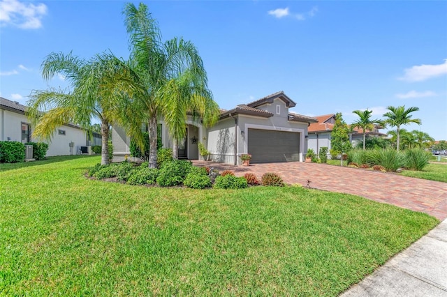 view of front of home featuring a front lawn, central air condition unit, and a garage