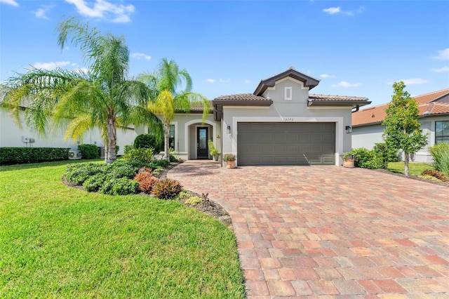 mediterranean / spanish-style home with a front yard and a garage