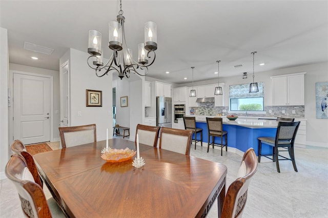 tiled dining room featuring a notable chandelier and sink