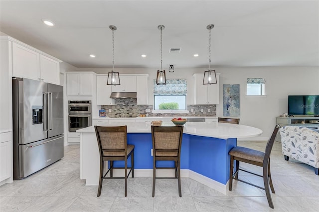 kitchen featuring stainless steel appliances, a wealth of natural light, a center island, and hanging light fixtures