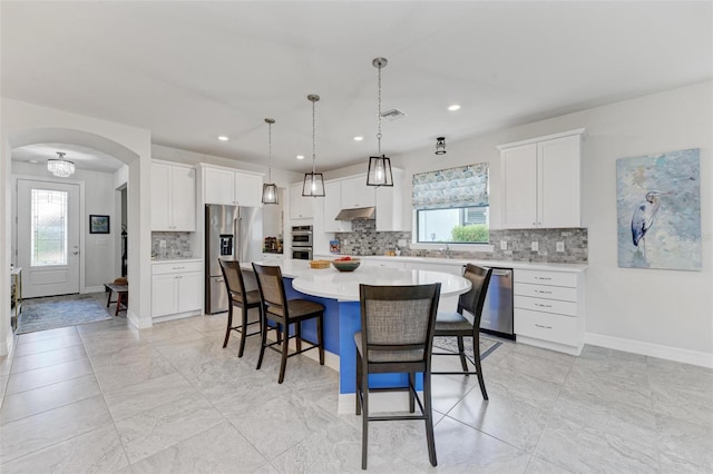 kitchen featuring stainless steel appliances, plenty of natural light, white cabinetry, and a center island