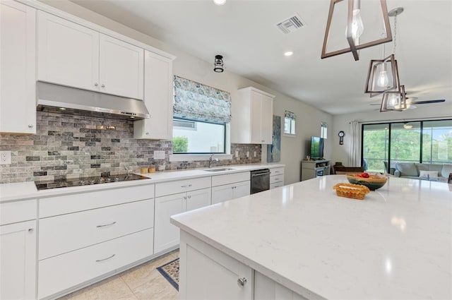 kitchen with decorative backsplash, white cabinets, pendant lighting, black electric stovetop, and sink