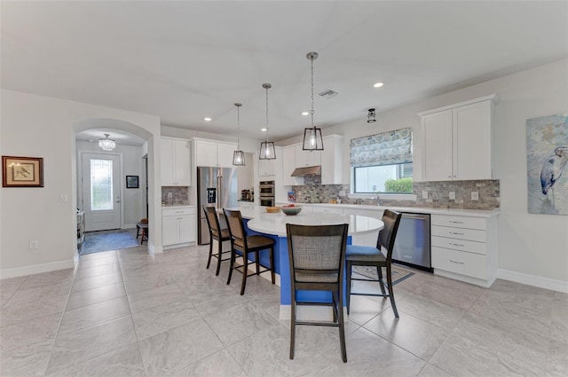 kitchen with a wealth of natural light, a center island, and stainless steel appliances