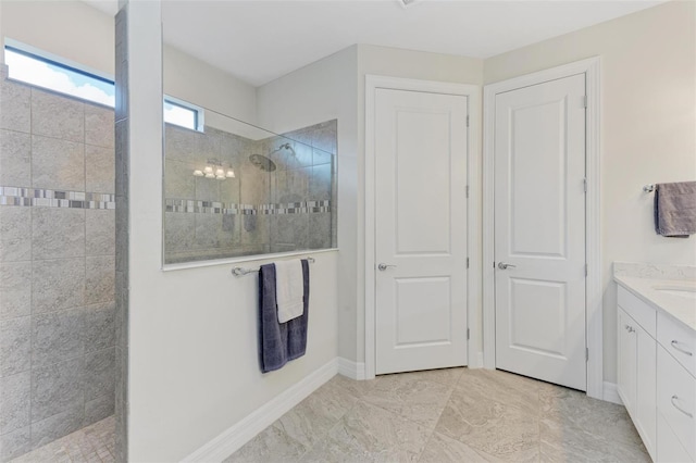 bathroom featuring tiled shower and vanity