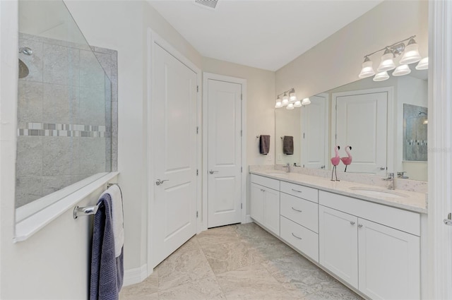 bathroom with vanity and tiled shower