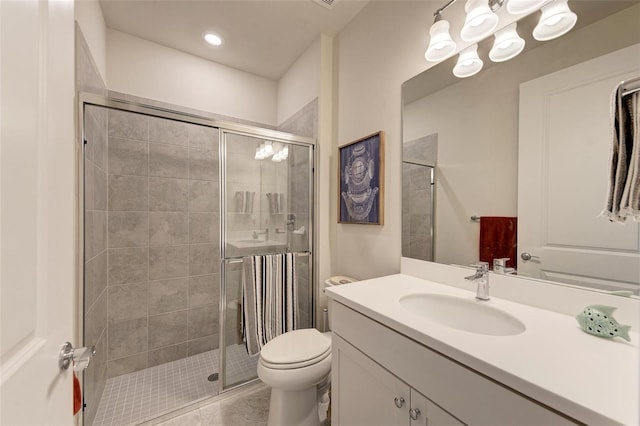 bathroom with vanity, toilet, tile patterned floors, and a shower with shower door