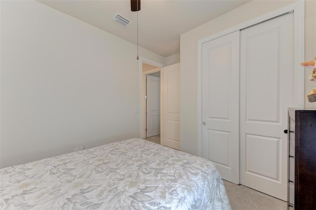 carpeted bedroom with ceiling fan and a closet