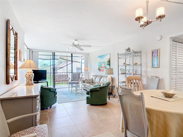 living room featuring ceiling fan with notable chandelier, floor to ceiling windows, and light tile patterned floors