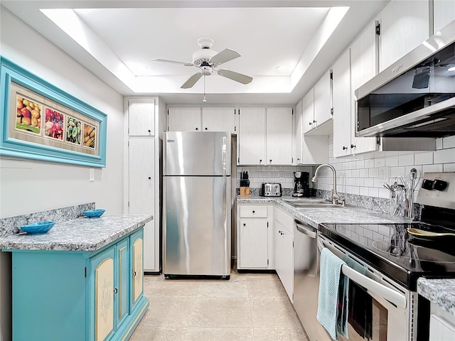 kitchen with sink, white cabinets, exhaust hood, a raised ceiling, and appliances with stainless steel finishes