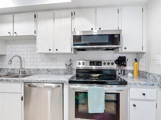 kitchen featuring stainless steel appliances, sink, tasteful backsplash, and white cabinetry