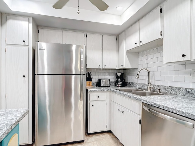 618 Bird Bay Dr S Unit 202, Venice, FL 34285 - kitchen with tasteful backsplash, a tray ceiling, a sink, a ceiling fan, and appliances with stainless steel finishes