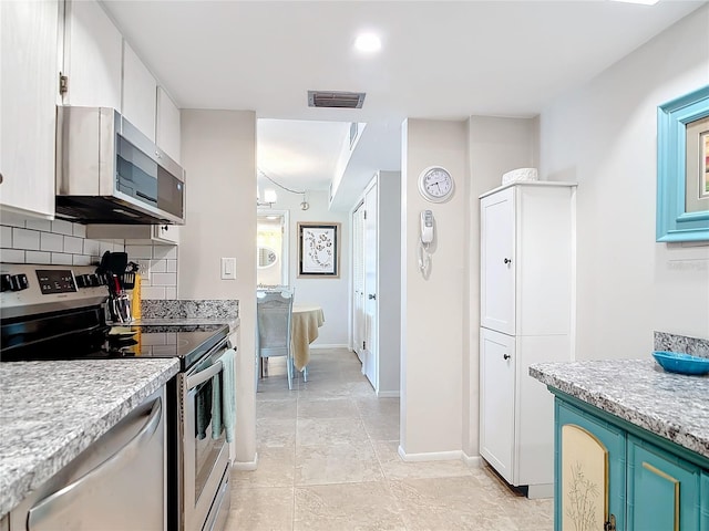 kitchen with appliances with stainless steel finishes, decorative backsplash, blue cabinets, and white cabinets