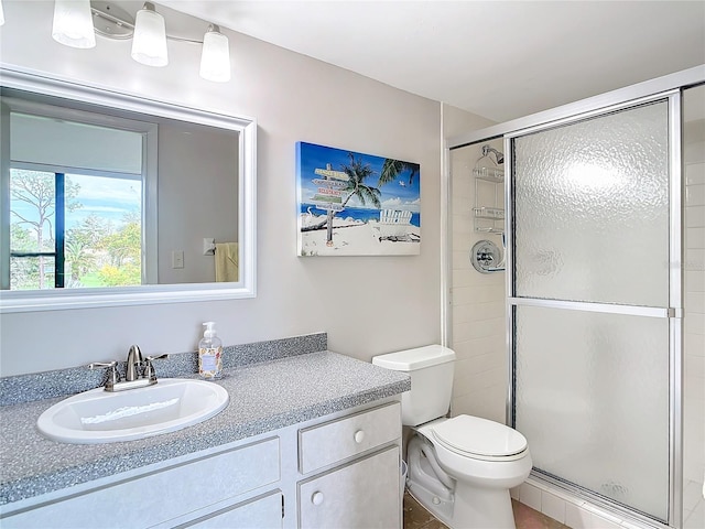 bathroom with vanity, toilet, an enclosed shower, and tile patterned floors