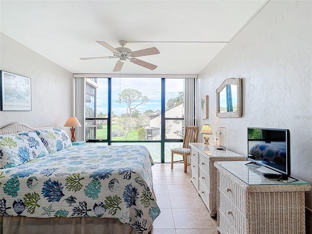 tiled bedroom featuring ceiling fan and floor to ceiling windows