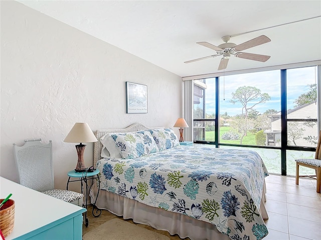 bedroom with multiple windows, light tile patterned floors, and ceiling fan