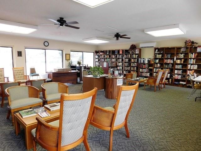 interior space with ceiling fan and a wall mounted AC