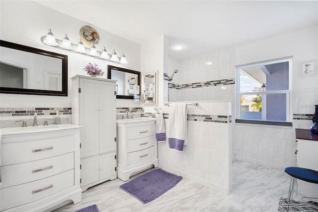 bathroom featuring tile walls, tiled shower, and vanity