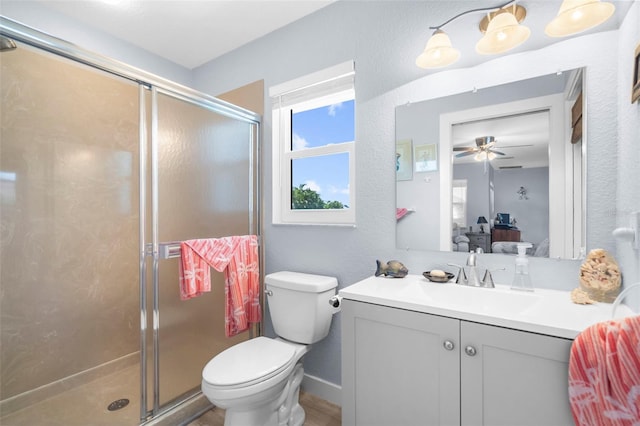 bathroom featuring walk in shower, vanity, toilet, and ceiling fan