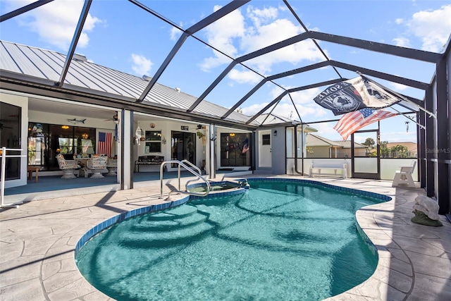 view of swimming pool with a patio, an in ground hot tub, ceiling fan, and glass enclosure