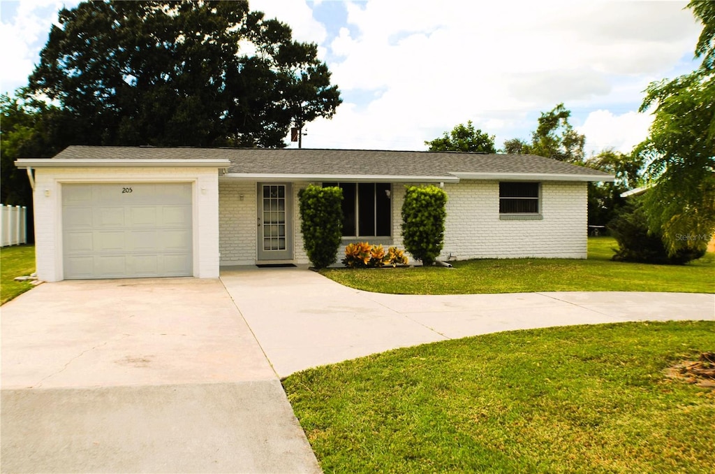 ranch-style house featuring a front lawn and a garage