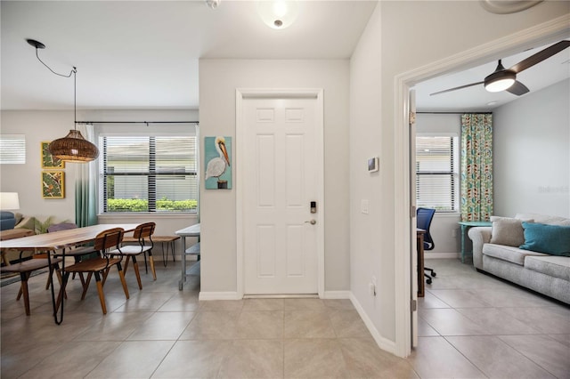 tiled entrance foyer featuring a wealth of natural light and ceiling fan