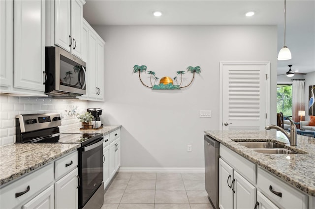 kitchen featuring ceiling fan, hanging light fixtures, sink, white cabinetry, and appliances with stainless steel finishes