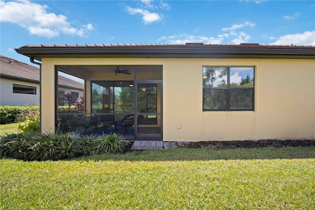 rear view of house featuring ceiling fan, a yard, and a patio area