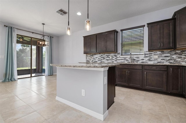 kitchen featuring pendant lighting, a center island, and tasteful backsplash