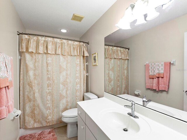 bathroom featuring tile patterned flooring, a shower with curtain, vanity, and toilet