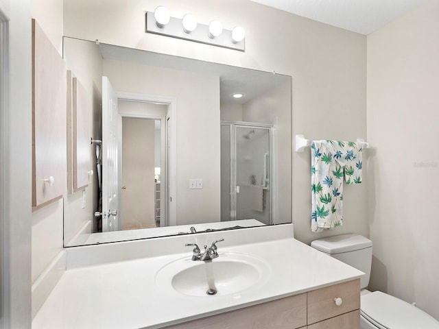 bathroom with vanity, toilet, and a shower with door