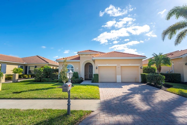 mediterranean / spanish-style home with a tiled roof, decorative driveway, a garage, a front lawn, and stucco siding