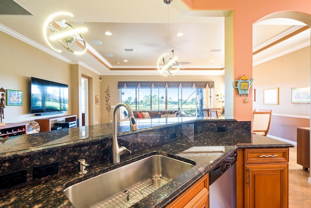 kitchen with open floor plan, crown molding, a sink, dishwasher, and brown cabinetry