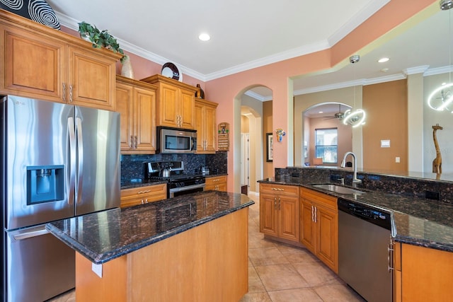 kitchen featuring appliances with stainless steel finishes, kitchen peninsula, crown molding, dark stone counters, and sink