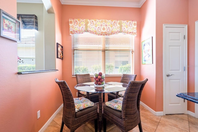 dining room featuring baseboards, light tile patterned flooring, and crown molding