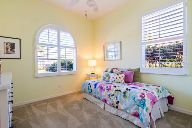 carpeted bedroom featuring multiple windows and ceiling fan