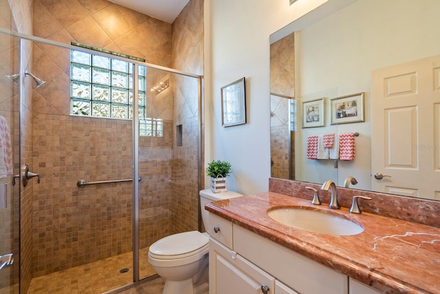 bathroom with walk in shower, vanity, and toilet