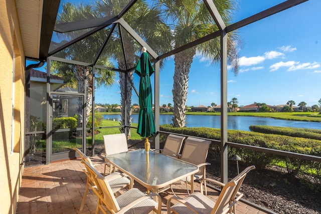 sunroom / solarium featuring a water view and outdoor dining space