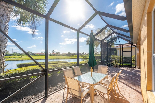 sunroom featuring a water view