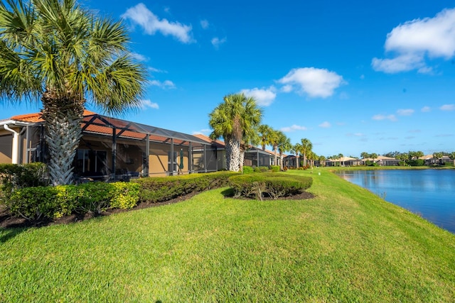 view of yard with a lanai and a water view