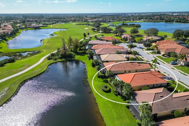 drone / aerial view featuring a residential view, golf course view, and a water view