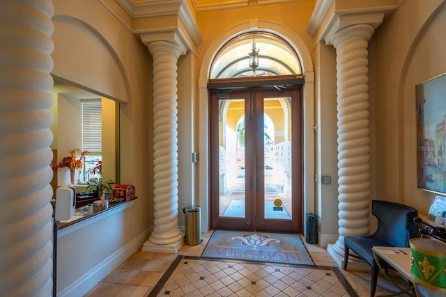 foyer featuring ornate columns, log walls, french doors, and light tile patterned floors
