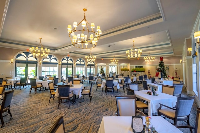 carpeted dining area with a raised ceiling and crown molding