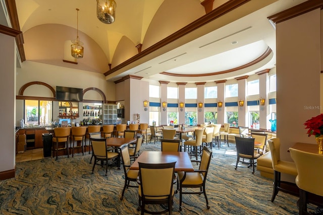 dining area featuring dark tile patterned flooring and a towering ceiling