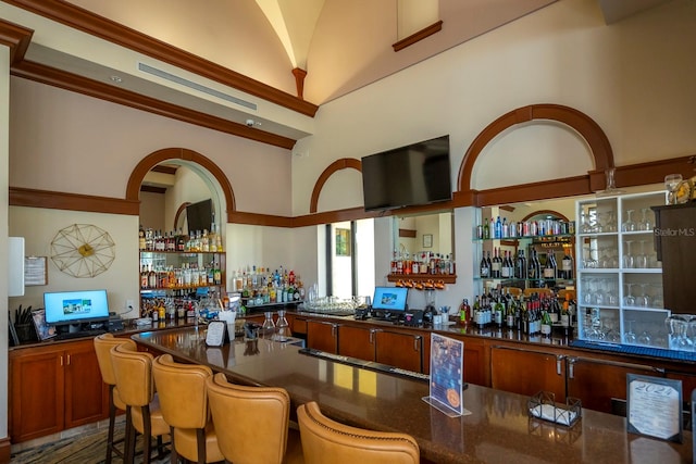 bar with dark stone counters and high vaulted ceiling