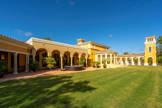 back of property with a lawn and a patio area