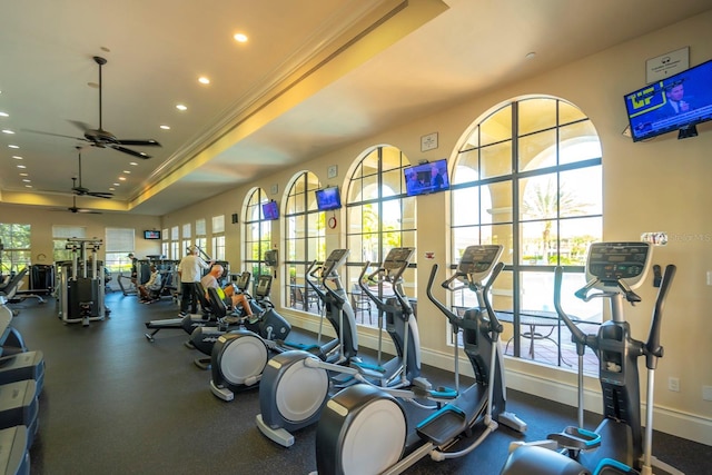 exercise room with recessed lighting, ornamental molding, baseboards, a raised ceiling, and ceiling fan